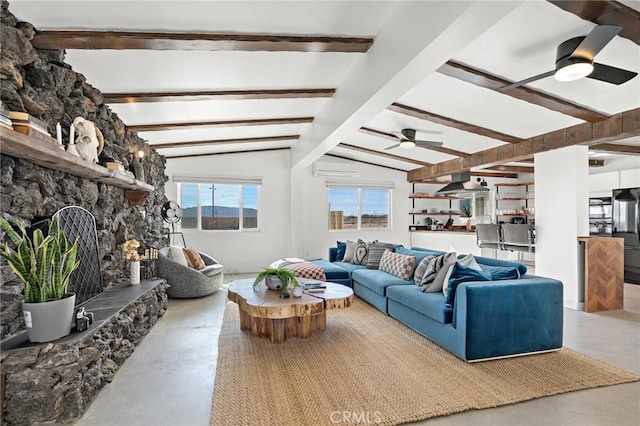 living room featuring vaulted ceiling with beams, finished concrete floors, a ceiling fan, and a stone fireplace