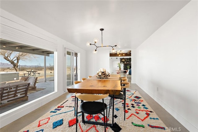 dining area with finished concrete flooring, baseboards, and a notable chandelier