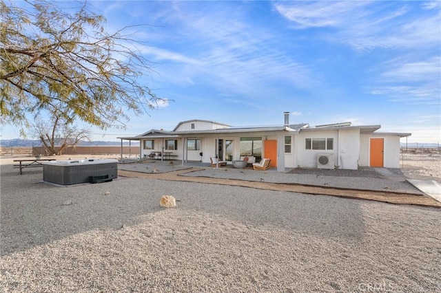 view of front of property featuring central AC, a patio, a hot tub, and fence