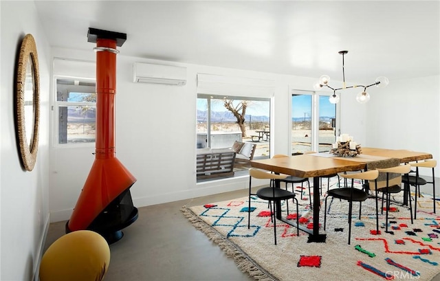 dining room with concrete flooring, an AC wall unit, and baseboards