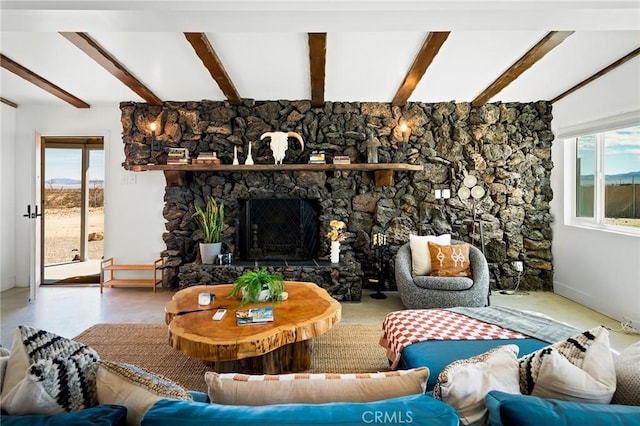 living area with beamed ceiling, a fireplace, and baseboards