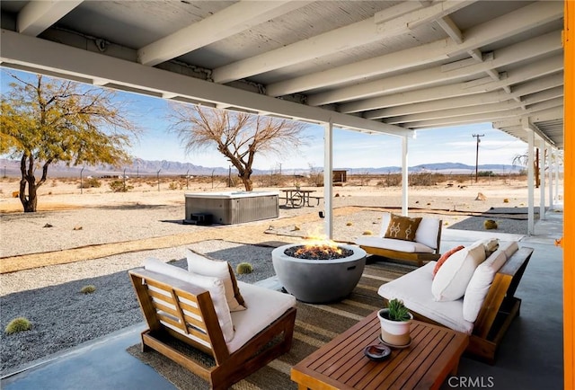 view of patio featuring a mountain view and an outdoor living space with a fire pit