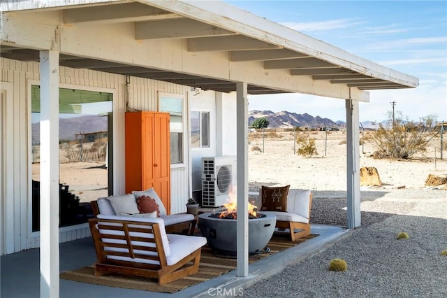 view of patio / terrace with ac unit, a mountain view, and a fire pit