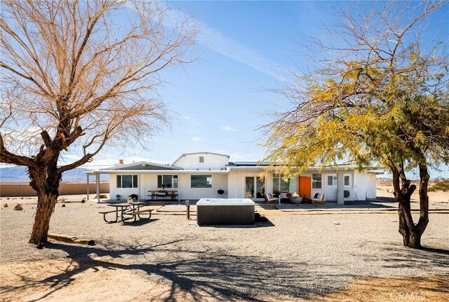 rear view of house featuring central AC, a patio area, fence, and a hot tub