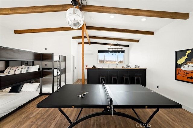 game room with baseboards, lofted ceiling with beams, wood finished floors, indoor wet bar, and recessed lighting