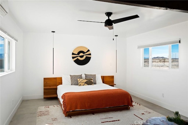 bedroom featuring a wall unit AC, ceiling fan, concrete floors, and baseboards