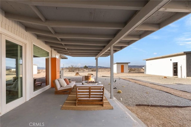 view of patio / terrace featuring an outbuilding and an outdoor fire pit