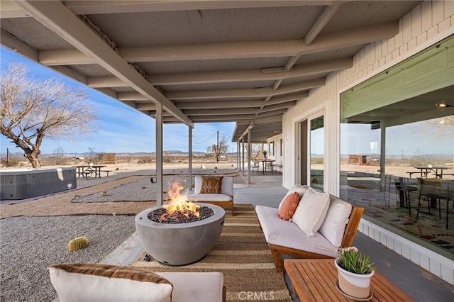 view of patio with an outdoor living space with a fire pit