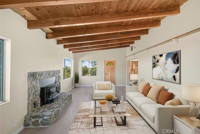 living room featuring beam ceiling, visible vents, wood ceiling, a wood stove, and wood finished floors