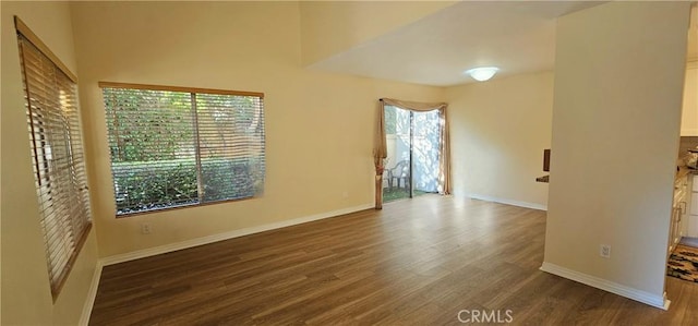 spare room featuring baseboards and wood finished floors