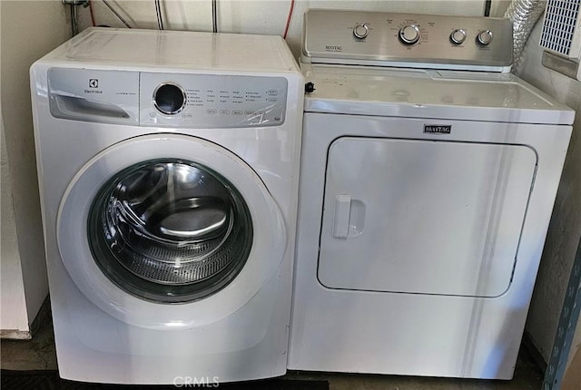 clothes washing area featuring laundry area and washing machine and clothes dryer