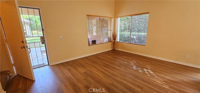 empty room featuring wood finished floors and baseboards