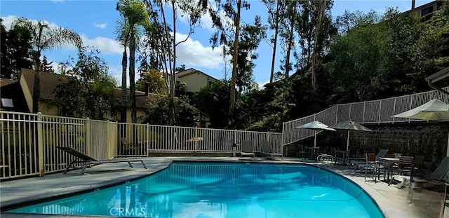 view of swimming pool featuring fence, a fenced in pool, and a patio