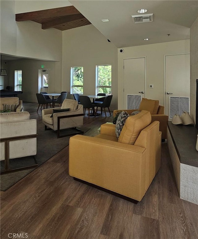 living room featuring beam ceiling, visible vents, and dark wood finished floors