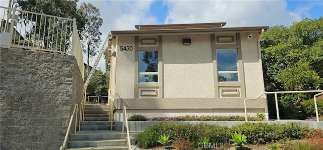 doorway to property featuring stucco siding