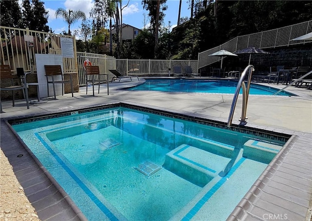 community pool featuring a patio and fence