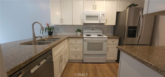 5440 Baltimore Dr Unit 144, La Mesa, CA 91942 - kitchen with white appliances, a sink, dark stone counters, light wood-style floors, and white cabinets