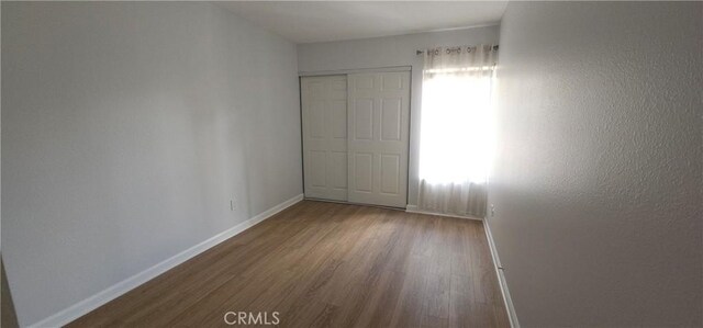 5440 Baltimore Dr Unit 144, La Mesa, CA 91942 - unfurnished bedroom featuring wood finished floors, baseboards, and a closet