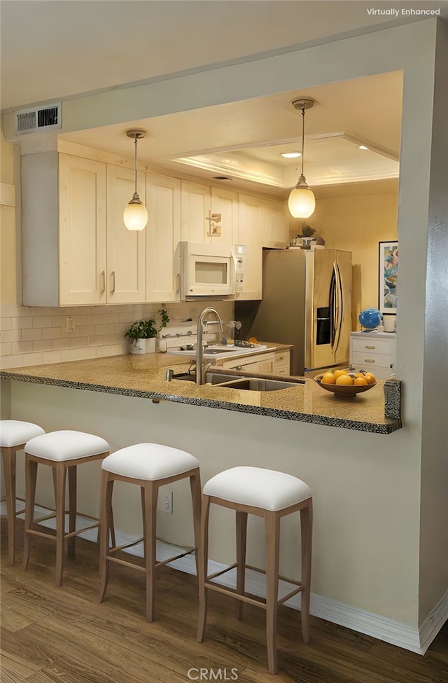 5440 Baltimore Dr Unit 144, La Mesa, CA 91942 - kitchen with white microwave, a tray ceiling, stainless steel fridge with ice dispenser, a peninsula, and tasteful backsplash