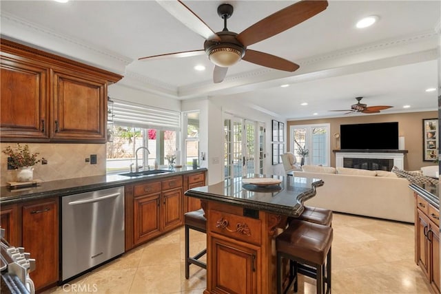 kitchen with tasteful backsplash, stainless steel dishwasher, a healthy amount of sunlight, a sink, and a kitchen bar