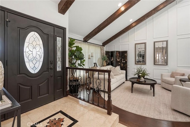 entryway featuring lofted ceiling with beams and a decorative wall