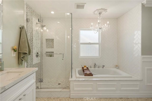 full bathroom featuring a stall shower, visible vents, an inviting chandelier, vanity, and a bath