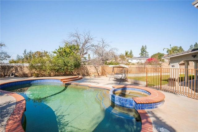 view of swimming pool with a patio, a fenced backyard, and a pool with connected hot tub