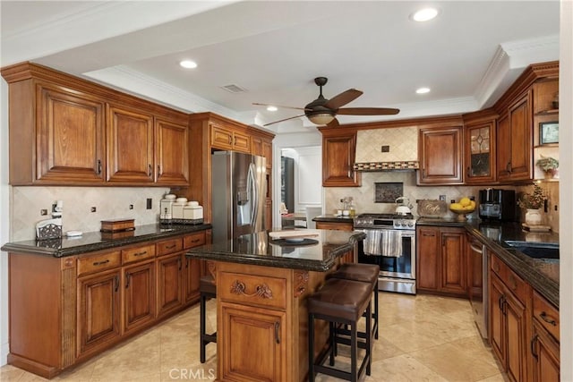 kitchen featuring a breakfast bar area, stainless steel appliances, visible vents, wall chimney range hood, and decorative backsplash