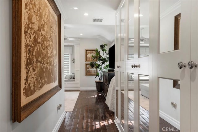 corridor featuring baseboards, visible vents, dark wood finished floors, crown molding, and recessed lighting