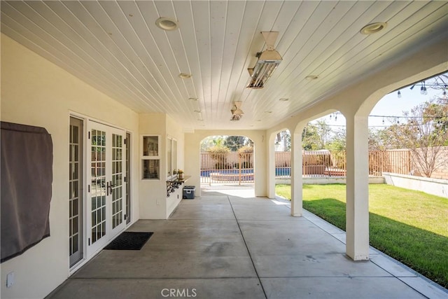 view of patio featuring french doors, a fenced backyard, and a fenced in pool