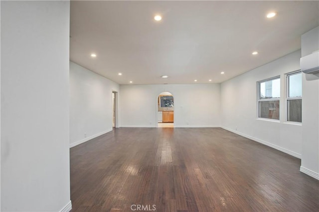 spare room featuring baseboards, dark wood-type flooring, and recessed lighting