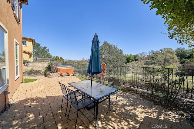 view of patio / terrace featuring a hot tub, outdoor dining area, and a fenced backyard