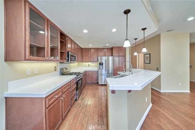 kitchen with stainless steel appliances, recessed lighting, a kitchen island with sink, and light wood-style floors