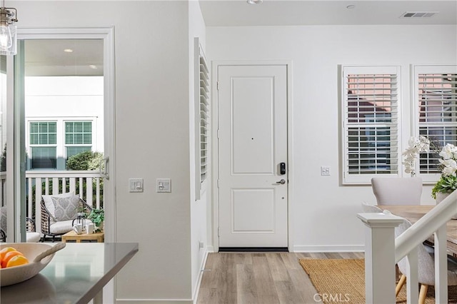 entrance foyer with light wood finished floors, baseboards, and visible vents