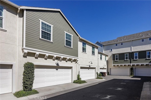 view of front facade with a garage, a residential view, and stucco siding