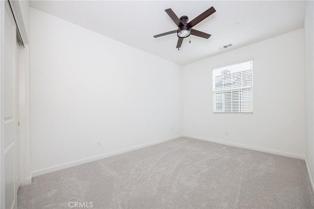 carpeted empty room with visible vents, ceiling fan, and baseboards