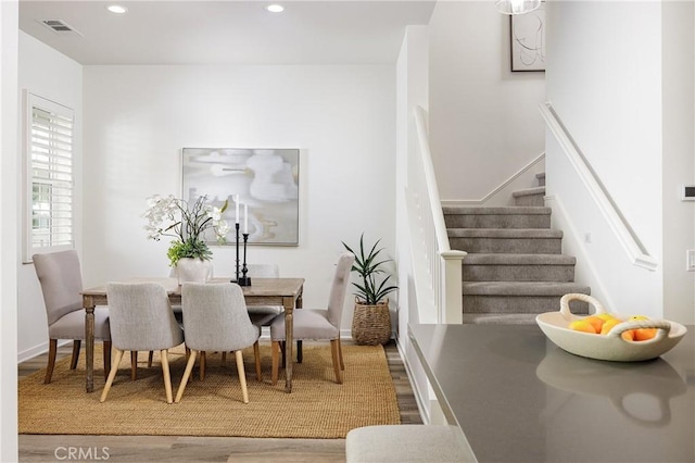 dining area with baseboards, visible vents, stairway, wood finished floors, and recessed lighting