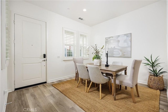 dining area featuring light wood finished floors, baseboards, visible vents, and recessed lighting