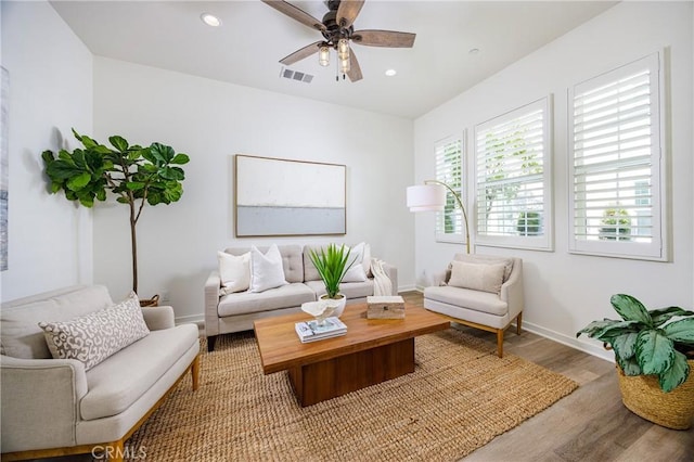 living area with a ceiling fan, visible vents, wood finished floors, and recessed lighting