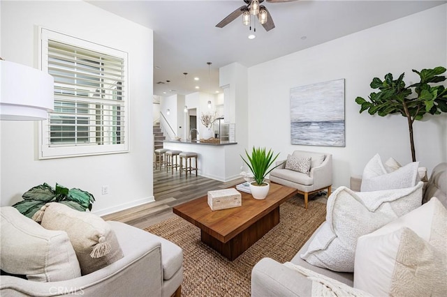 living room featuring recessed lighting, wood finished floors, a ceiling fan, baseboards, and stairs