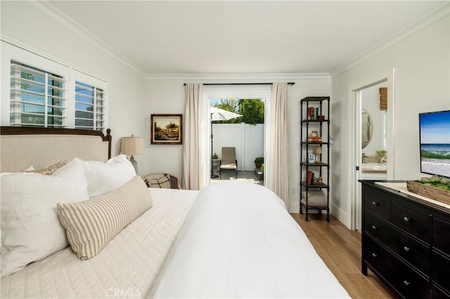 bedroom featuring access to outside, crown molding, baseboards, and wood finished floors