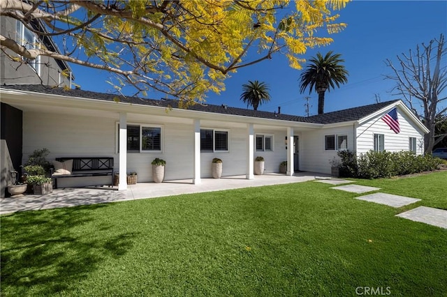 rear view of house with a lawn and a patio