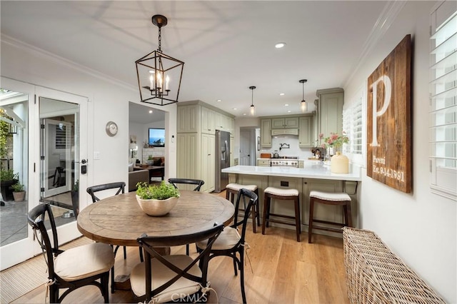 dining room featuring light wood-type flooring, recessed lighting, plenty of natural light, and crown molding