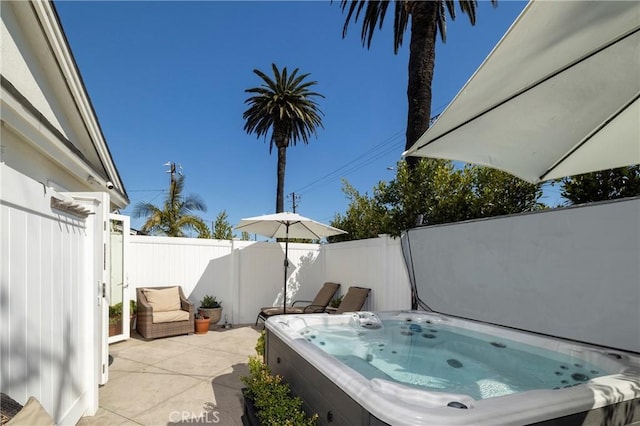 view of patio with fence and a hot tub