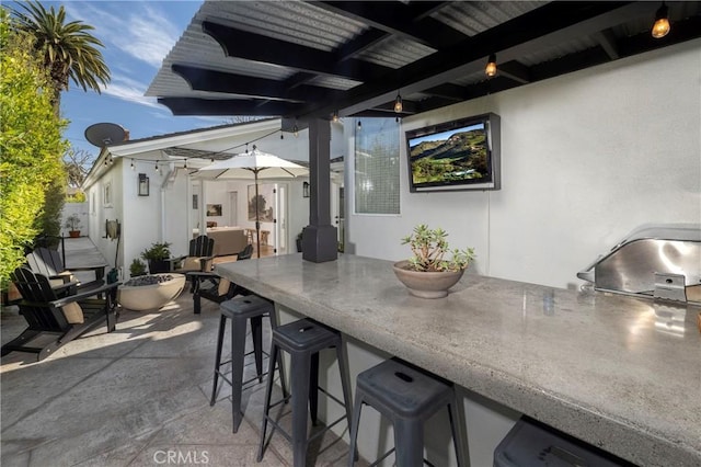 view of patio with outdoor wet bar, grilling area, and an outdoor kitchen