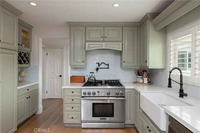 kitchen with light countertops, appliances with stainless steel finishes, backsplash, and a sink