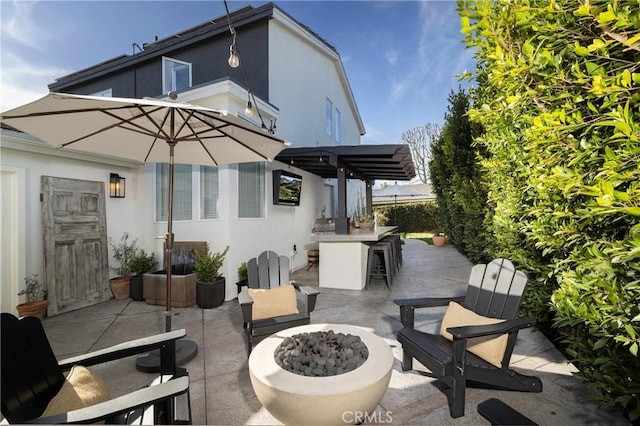 view of patio / terrace with a fire pit and outdoor dry bar