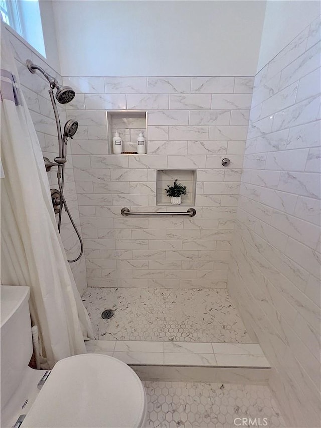 full bath with a tile shower and toilet