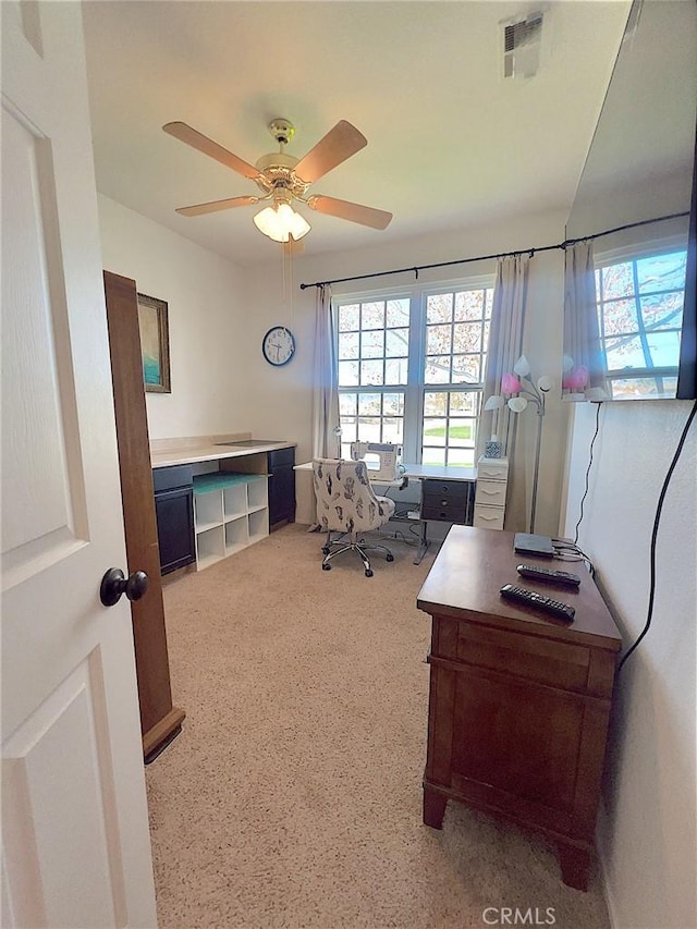 office space featuring a healthy amount of sunlight, visible vents, and a ceiling fan