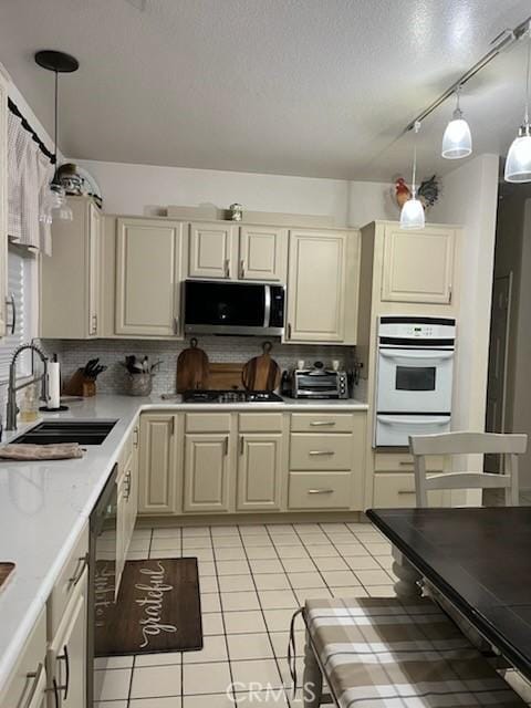 kitchen featuring a warming drawer, stainless steel microwave, a sink, gas cooktop, and oven